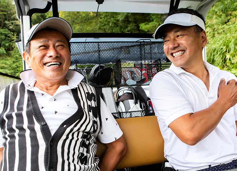 Adult father and son in a golf cart at the course. -767x554.jpg