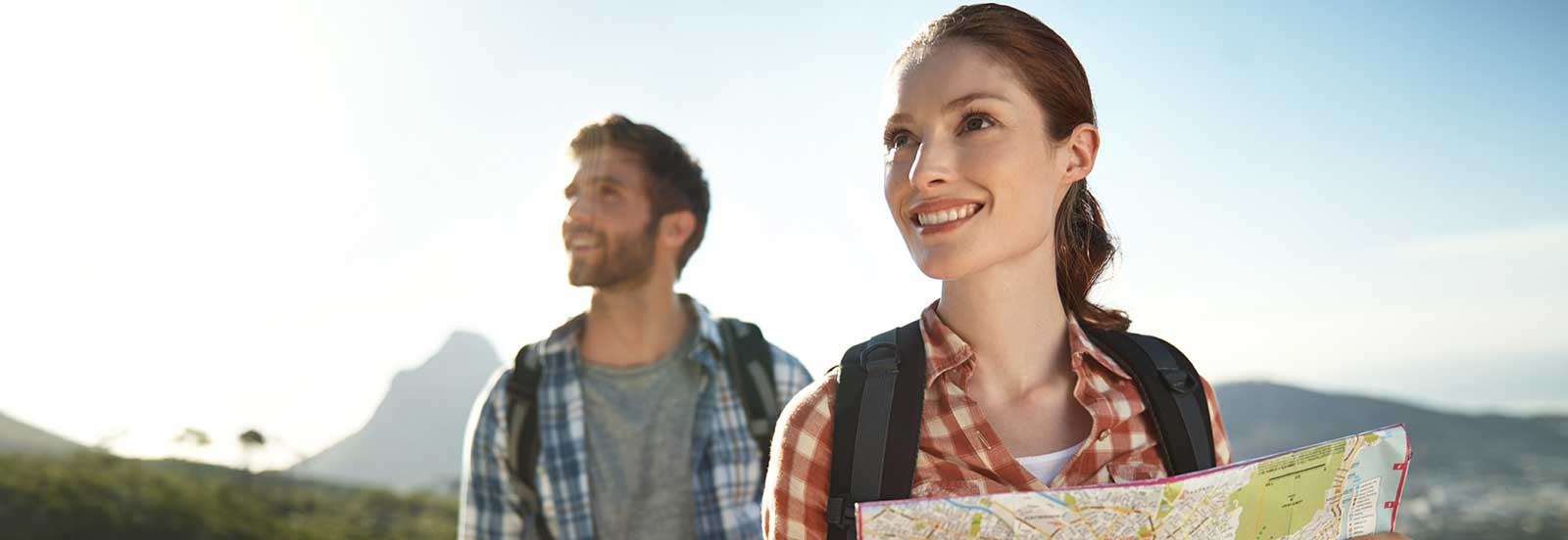 A couple hiking outdoors. The woman leads with the map. -1600x552.jpg